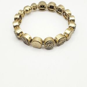 Golden bangle bracelet crafted with laser-etched "coin" medallions and faux-diam
